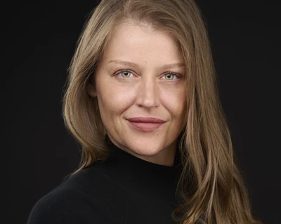 Professional creative headshot of influencer in black turtleneck against dark backdrop
